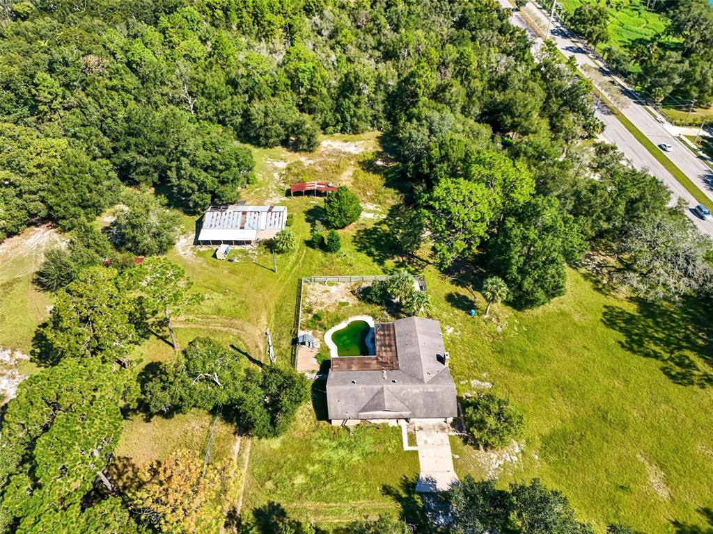 An aerial view shows a house with a pool, outbuildings, and trees on a large lot — 51 E PONKAN ROAD, APOPKA, FL