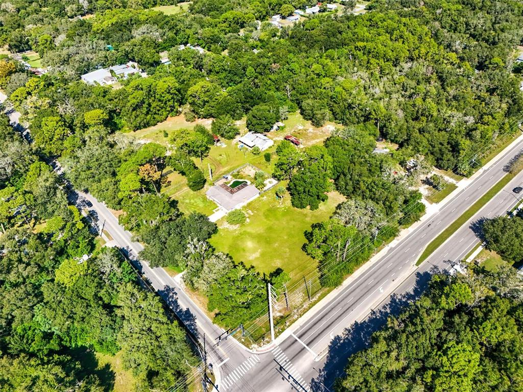 An aerial view shows a house with a pool on a large, wooded corner lot — 51 E PONKAN ROAD, APOPKA, FL
