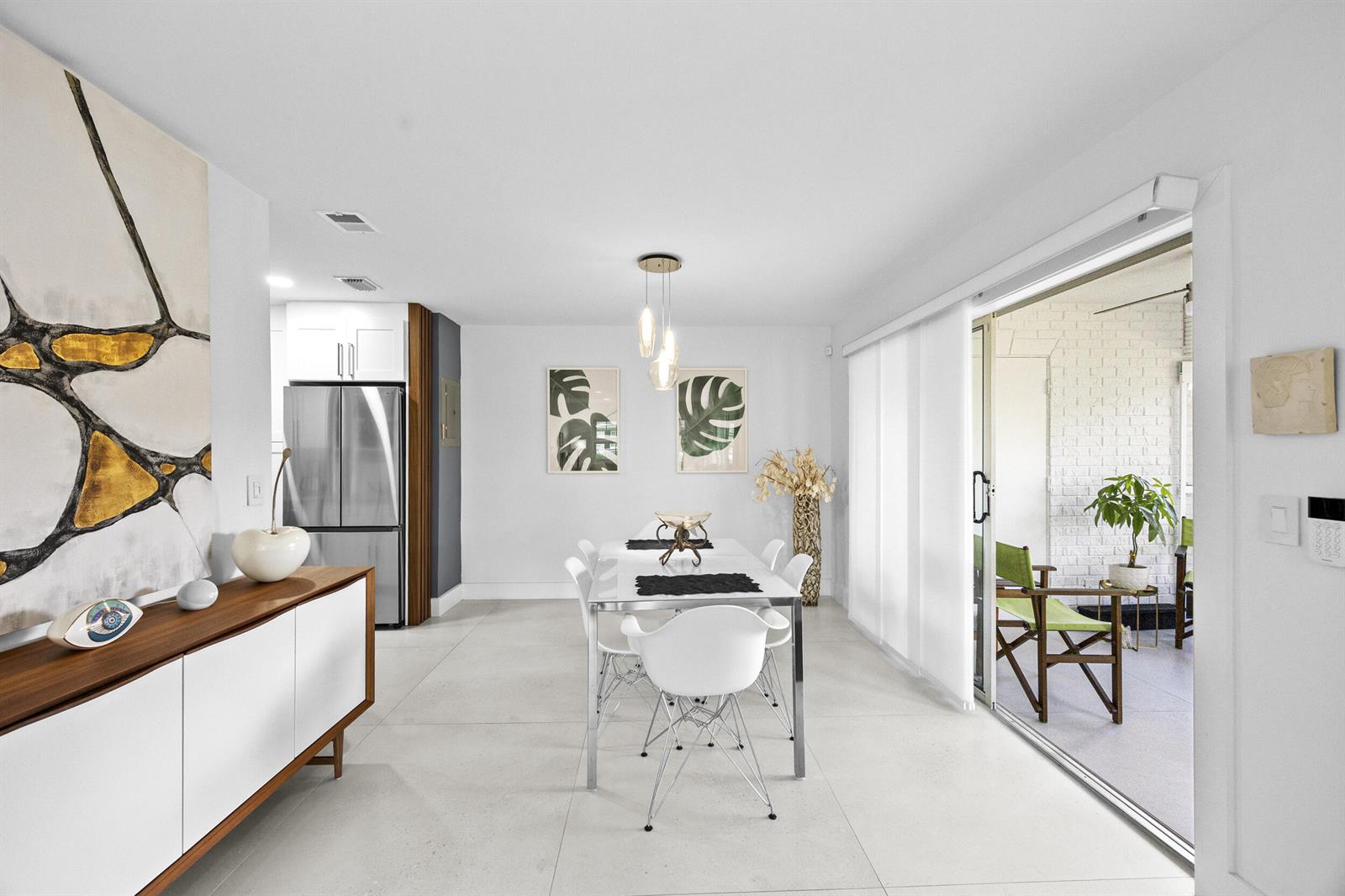 A modern dining room features white tile floors, a glass table, and a sliding glass door — 10137 S 40th Way # 233, Boynton Beach FL 33436, BOYNTON BEACH, FL