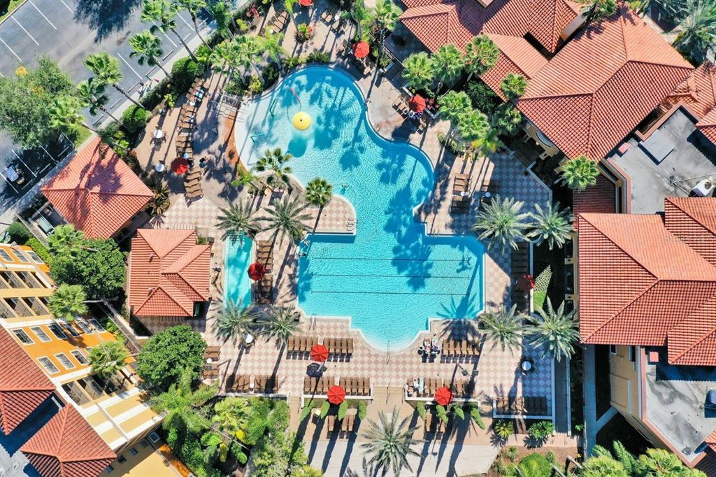 Aerial view of a resort-style swimming pool surrounded by buildings with terracotta tile roofs — 12544 FLORIDAYS RESORT DRIVE UNIT 106B, ORLANDO, FL