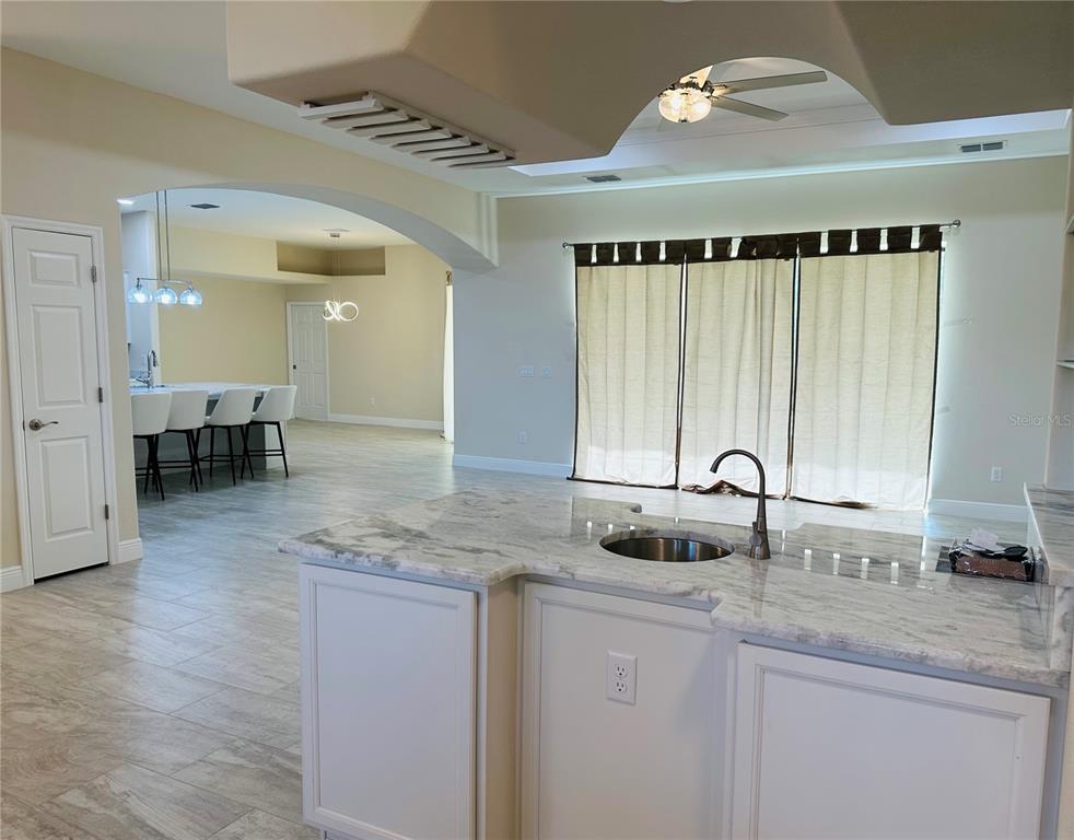 A kitchen island with a sink sits in the foreground of an open-concept living space — 5780 N LENA DRIVE, BEVERLY HILLS, FL