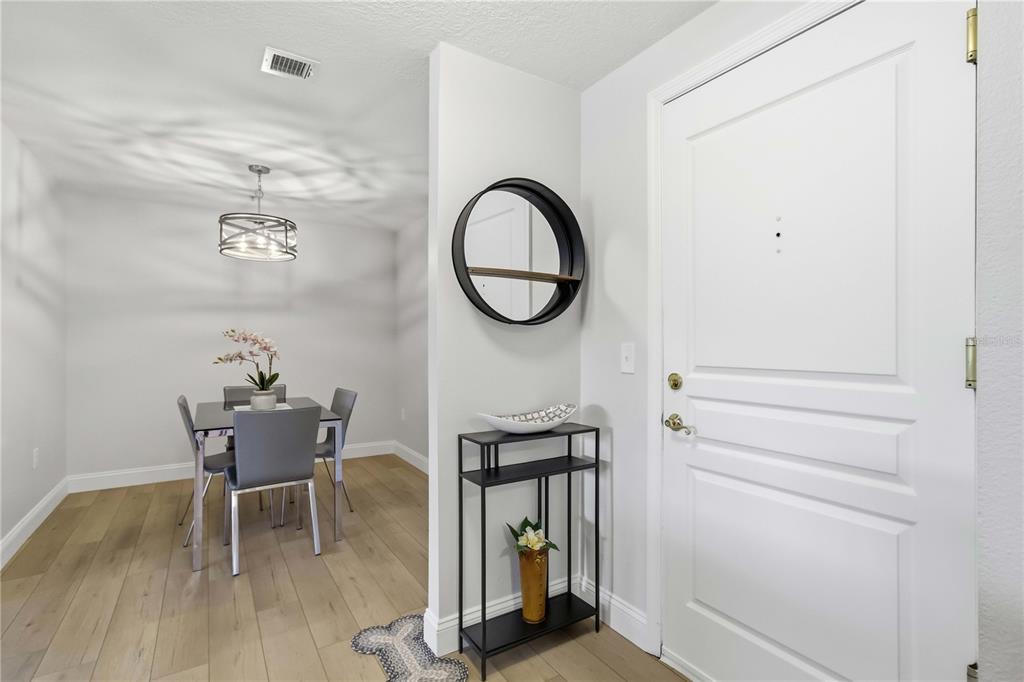 A dining area with a table and chairs is visible next to an entryway with decor — 750 N TAMIAMI TRAIL UNIT 312, SARASOTA, FL