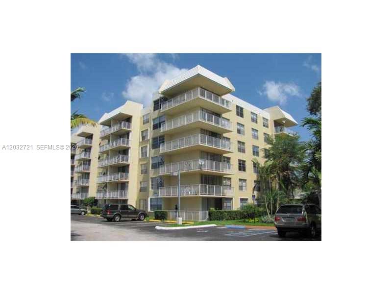 A multi-story apartment building with balconies and a parking lot in the foreground — 13100 SW 92nd Ave, Miami FL 33176, MIAMI, FL