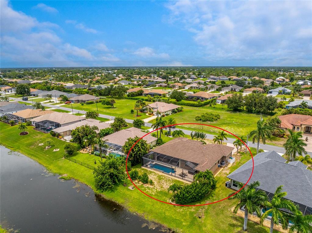 An aerial view of a suburban house featuring a screened-in pool and backyard lawn — 4 WHITE MARSH LANE, ROTONDA WEST, FL
