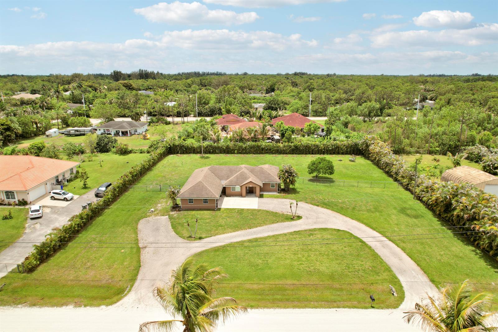 An aerial view shows a single-story house with a circular driveway on a large lot — 12628 N 70th Pl Place N, FL 33412, FL