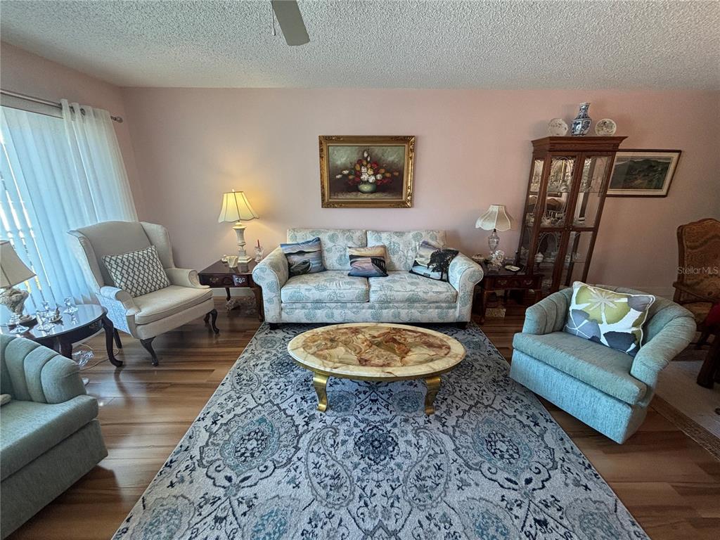 A living room features a floral sofa, two armchairs, a coffee table, and a rug — 2262 SWEDISH DR. UNIT 34, CLEARWATER, FL