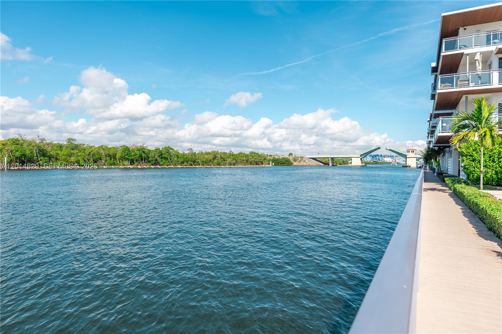 A waterfront view features a modern apartment building balcony overlooking a river and drawbridge — 6100 N Ocean Dr # 3N, Hollywood FL 33019, HOLLYWOOD, FL
