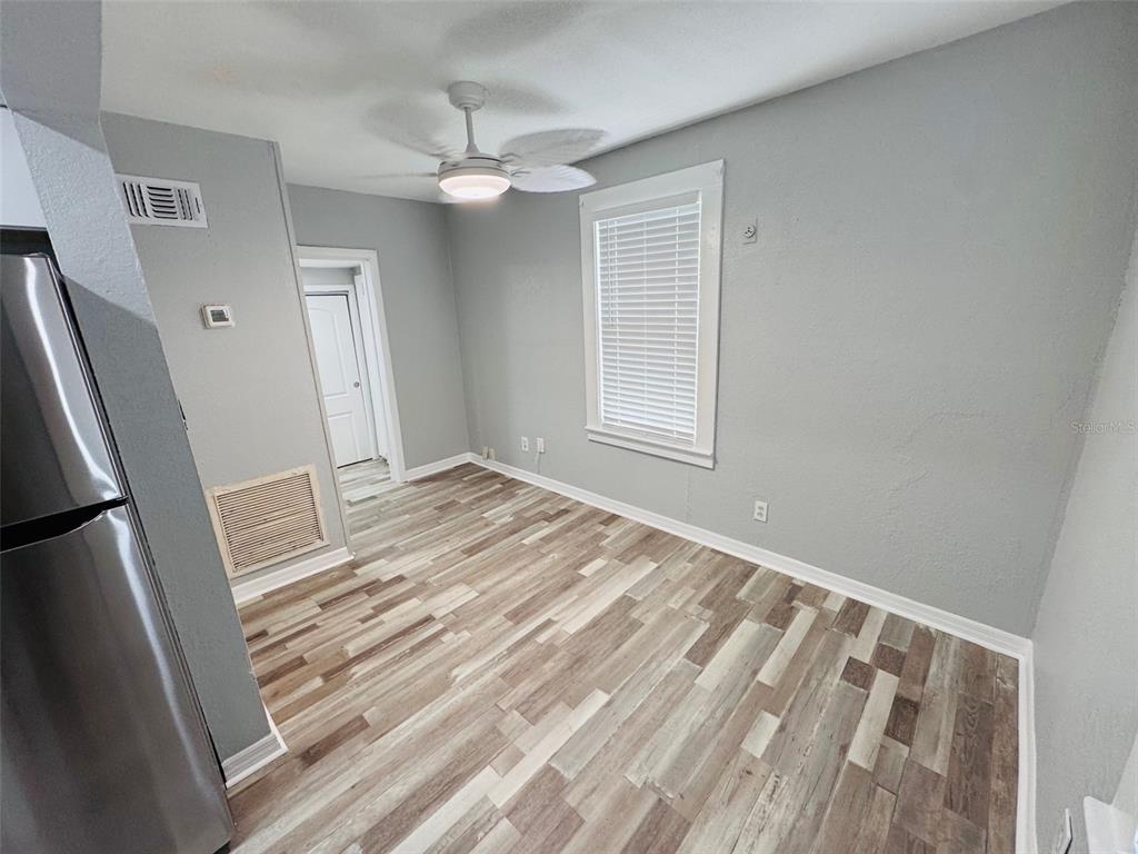 A room with gray walls, wood-look flooring, a ceiling fan, and a window with blinds — 128 W NORTH STREET, TAMPA, FL