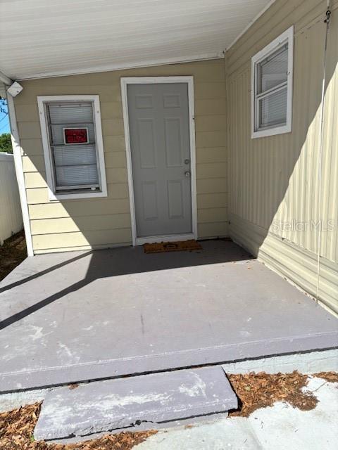 A gray door and a window with a red sign are on the exterior wall — 9145 RALLY LANE, HOLIDAY, FL