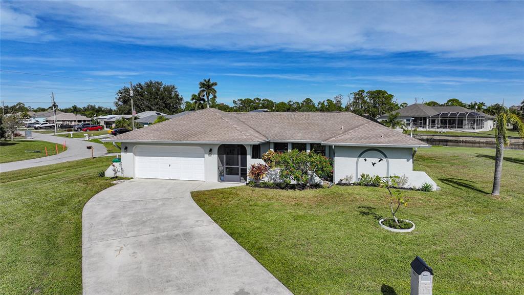 A single-story house with a white garage, a screened entryway, and a concrete driveway — 3522 FOX TERRACE, PORT CHARLOTTE, FL