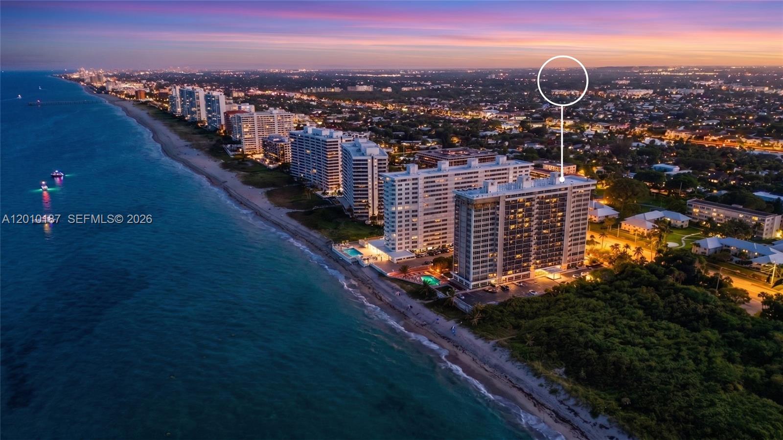 An aerial view shows a high-rise residential building situated along a sandy beach at sunset — 1180 S Ocean Boulevard # 12F, Boca Raton FL 33432, BOCA RATON, FL