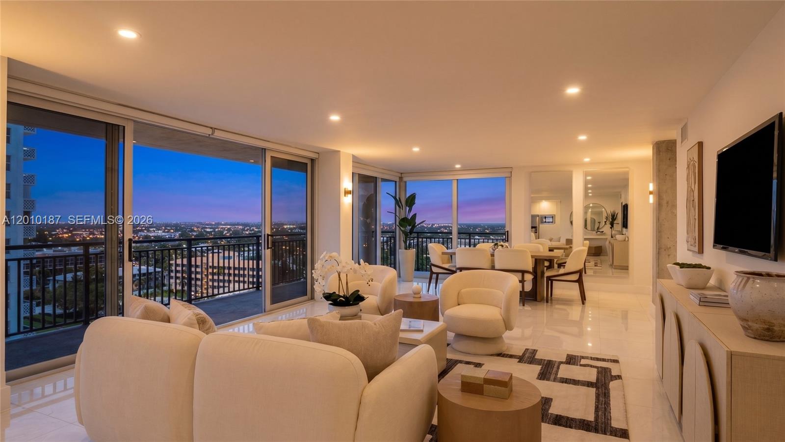 A bright living and dining area features floor-to-ceiling windows with a sunset city view — 1180 S Ocean Boulevard # 12F, Boca Raton FL 33432, BOCA RATON, FL