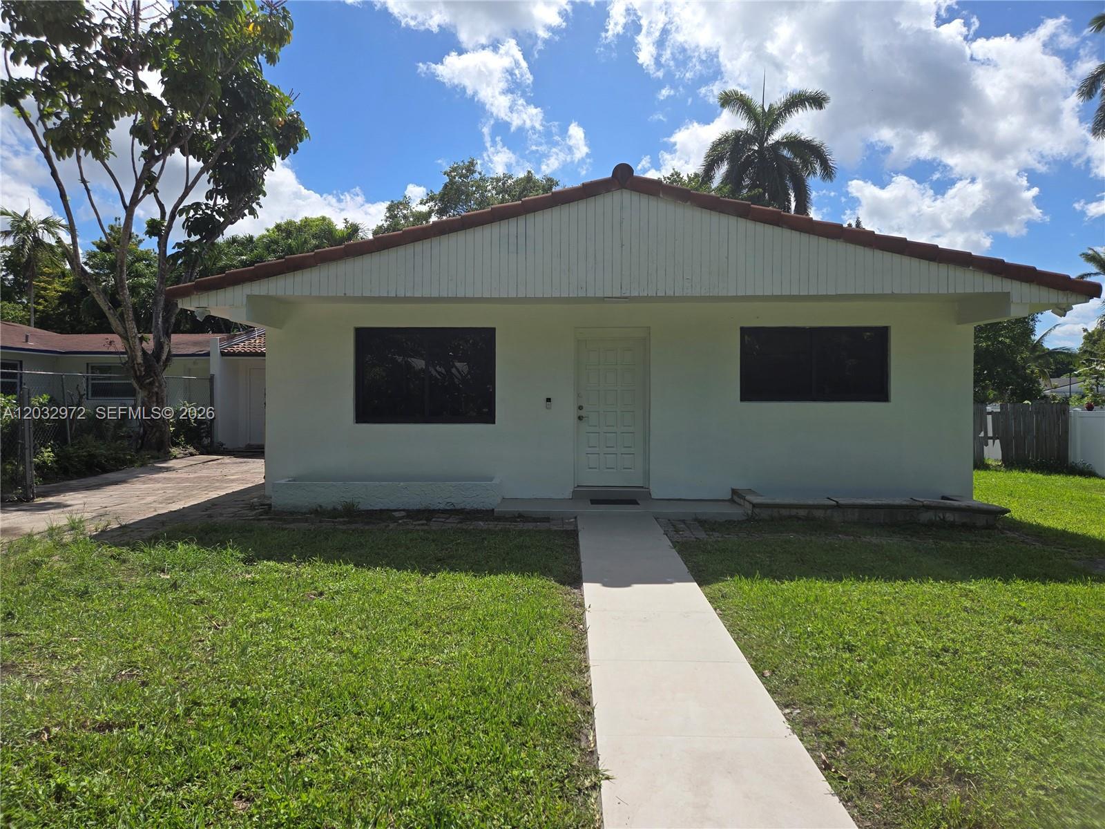 A white single-story house with a tiled roof and a concrete walkway in the front yard — 13100 NE 3rd Ct # 1, North Miami FL 33161, NORTH MIAMI, FL