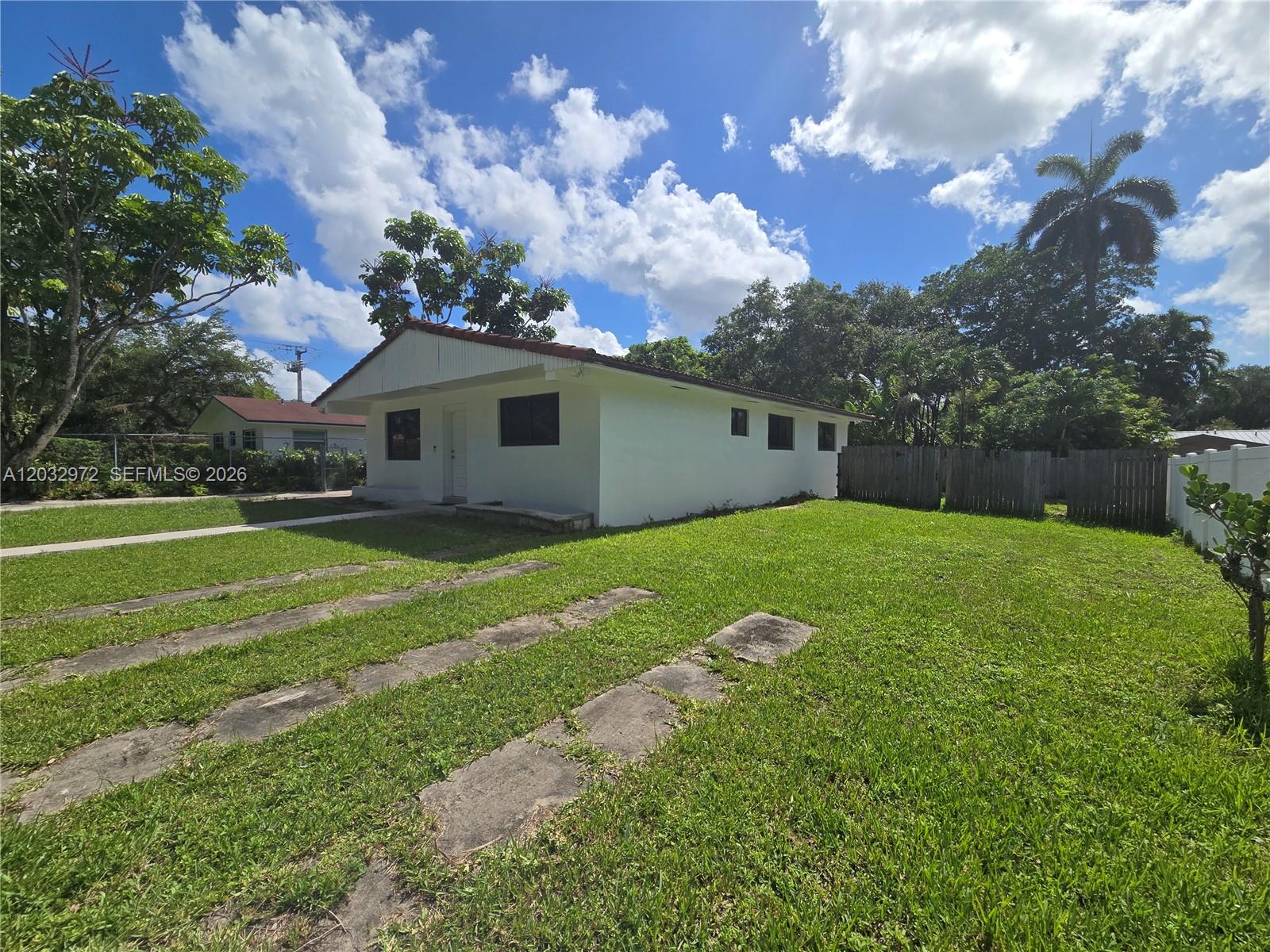 A white, single-story house with a concrete driveway sits on a grassy lot — 13100 NE 3rd Ct # 1, North Miami FL 33161, NORTH MIAMI, FL