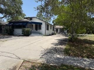 A single-story house with a blue awning over the porch and a concrete driveway — 5845 E MAIN STREET E, NEW PORT RICHEY, FL