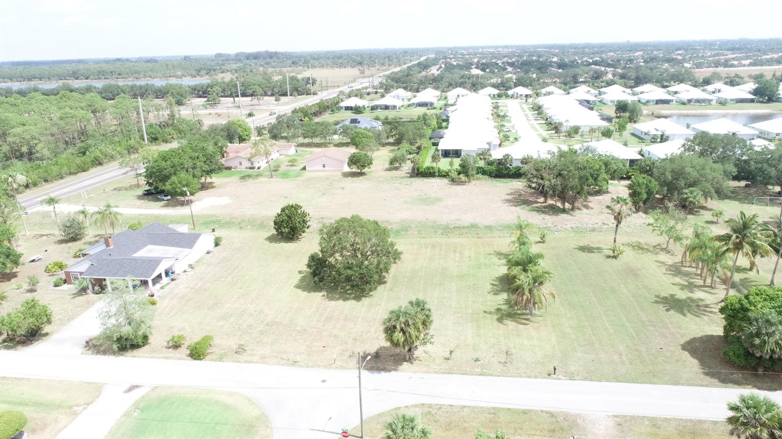 An aerial view shows a large, grassy residential lot with scattered trees and nearby houses — 4720 58th Ave Avenue, Vero Beach FL 32967, VERO BEACH, FL