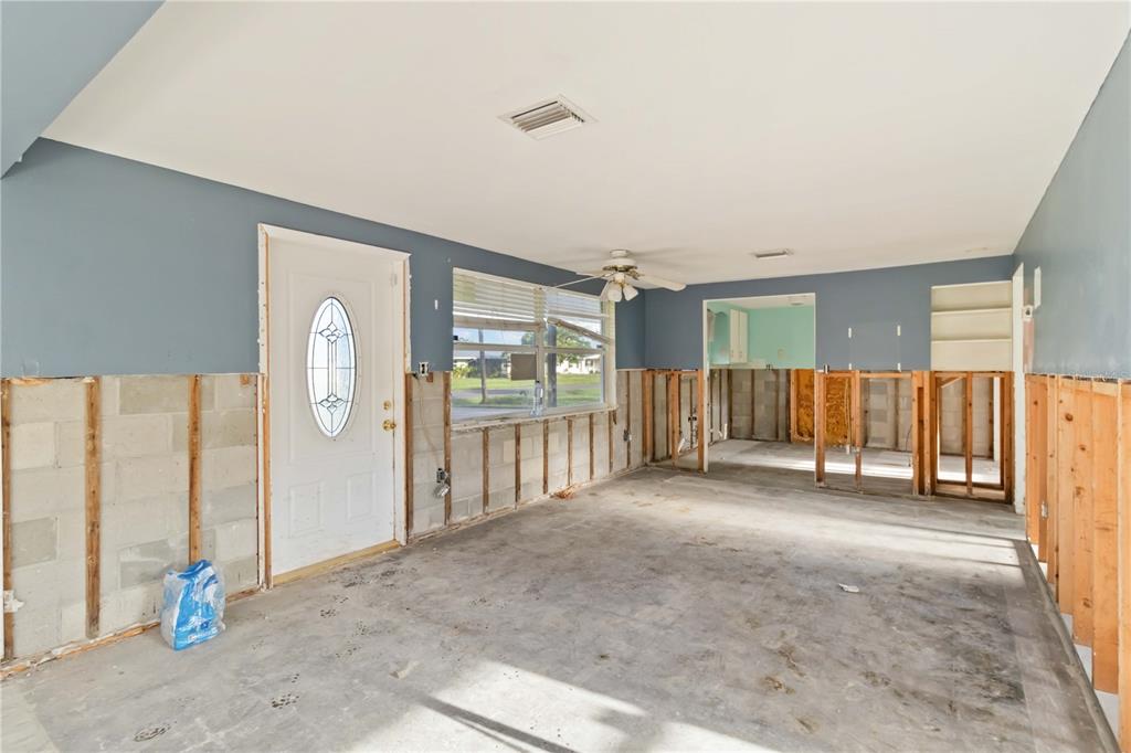 An unfinished room with exposed wall studs, concrete block walls, and a white entry door — 1255 S MARYKNOLL ROAD, ENGLEWOOD, FL