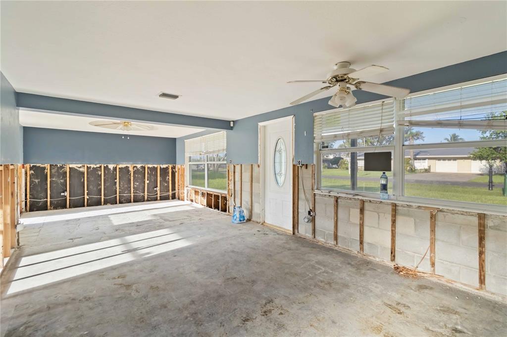 An unfinished room with exposed wall studs, concrete floors, and a ceiling fan — 1255 S MARYKNOLL ROAD, ENGLEWOOD, FL