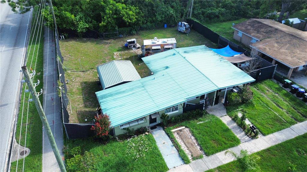 An aerial view shows a single-story house with a green metal roof and a fenced yard — 6923 ANOKA DRIVE, ORLANDO, FL