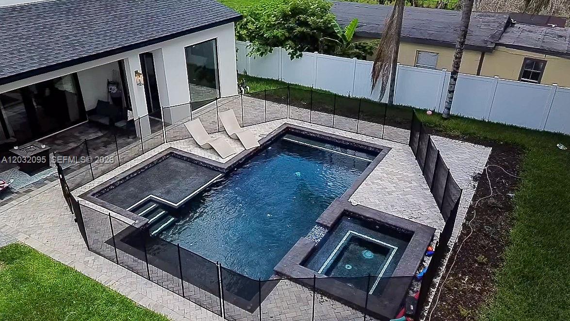 An aerial view shows a rectangular swimming pool and spa enclosed by a black fence — 1605 Jessamine Ave, Orlando FL 32806, ORLANDO, FL
