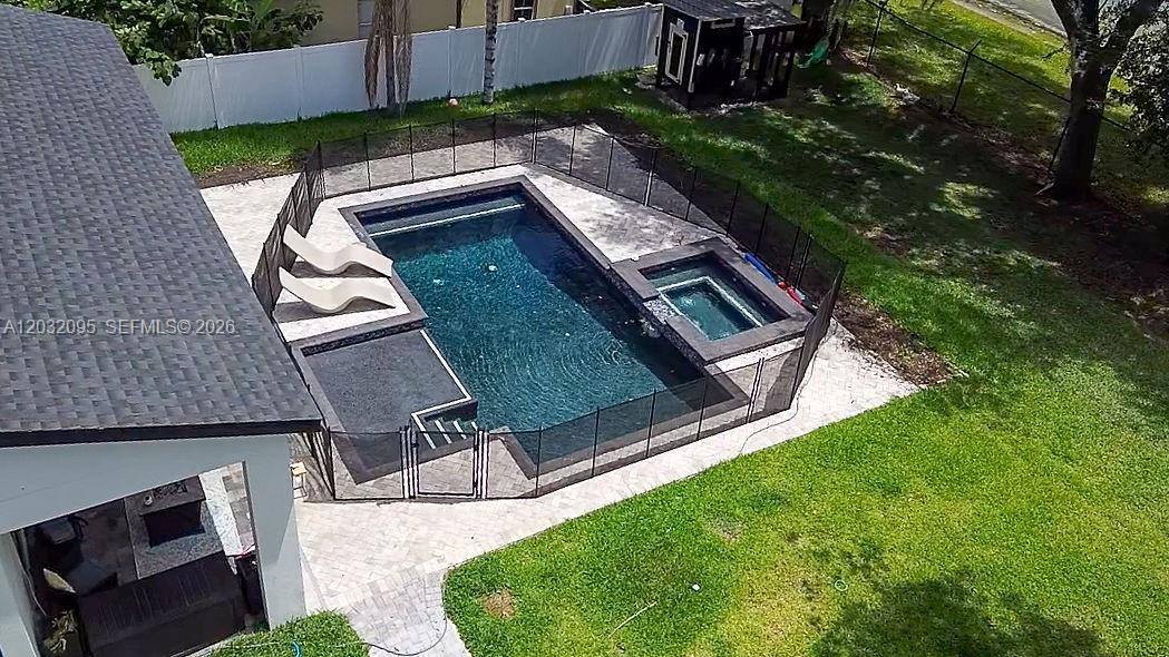 An aerial view shows a swimming pool and spa enclosed by a black safety fence — 1605 Jessamine Ave, Orlando FL 32806, ORLANDO, FL