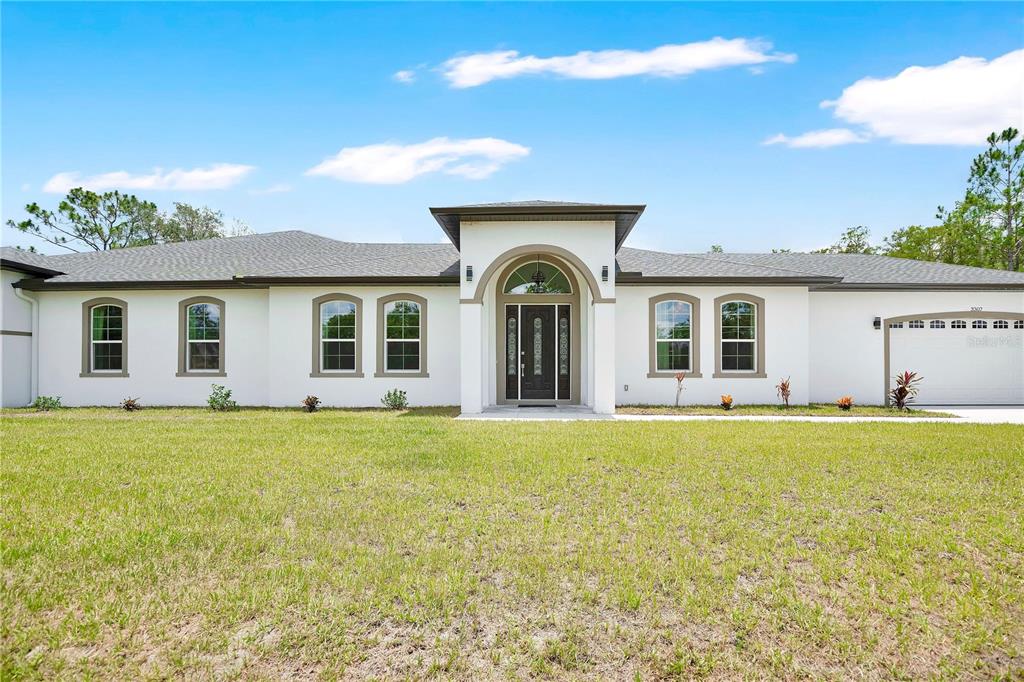 A single-story white house with a central arched entryway and a two-car garage — 3307 DALLAS BOULEVARD, ORLANDO, FL