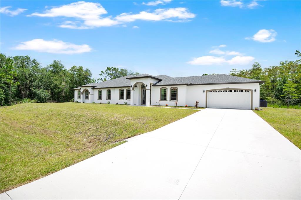 A single-story white house with a gray roof and a concrete driveway sits on grass — 3307 DALLAS BOULEVARD, ORLANDO, FL