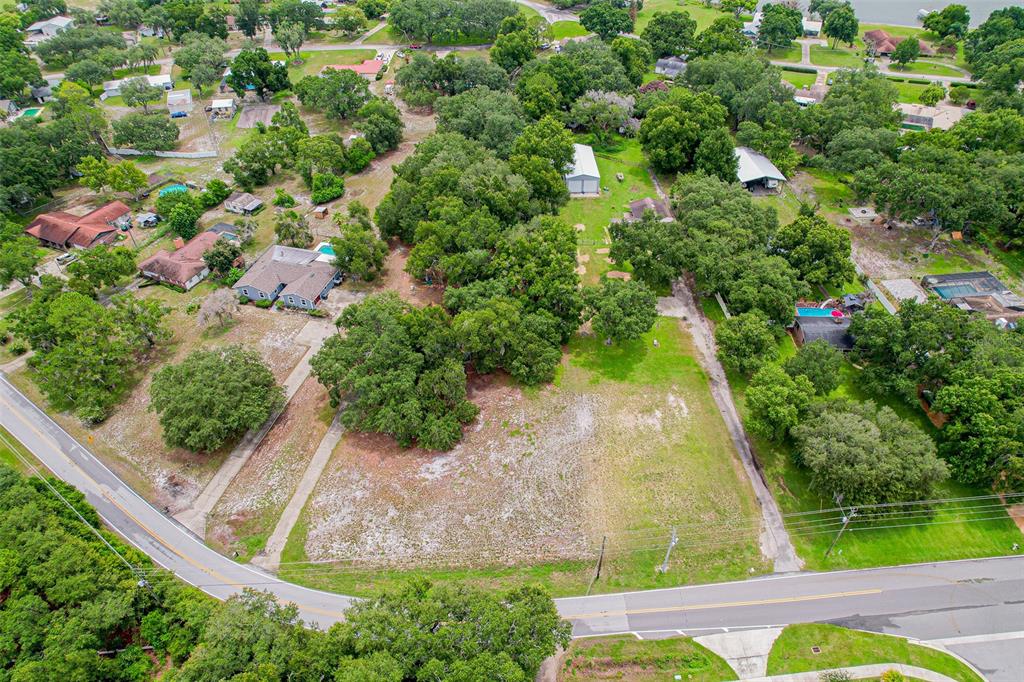 An aerial view shows a large, grassy vacant lot surrounded by trees and residential houses — 4604 CRYSTAL BEACH ROAD, WINTER HAVEN, FL