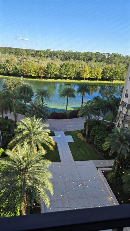 An elevated view shows a paved courtyard with string lights overlooking a lake and trees — 14501 GROVE RESORT AVENUE UNIT 1603, WINTER GARDEN, FL