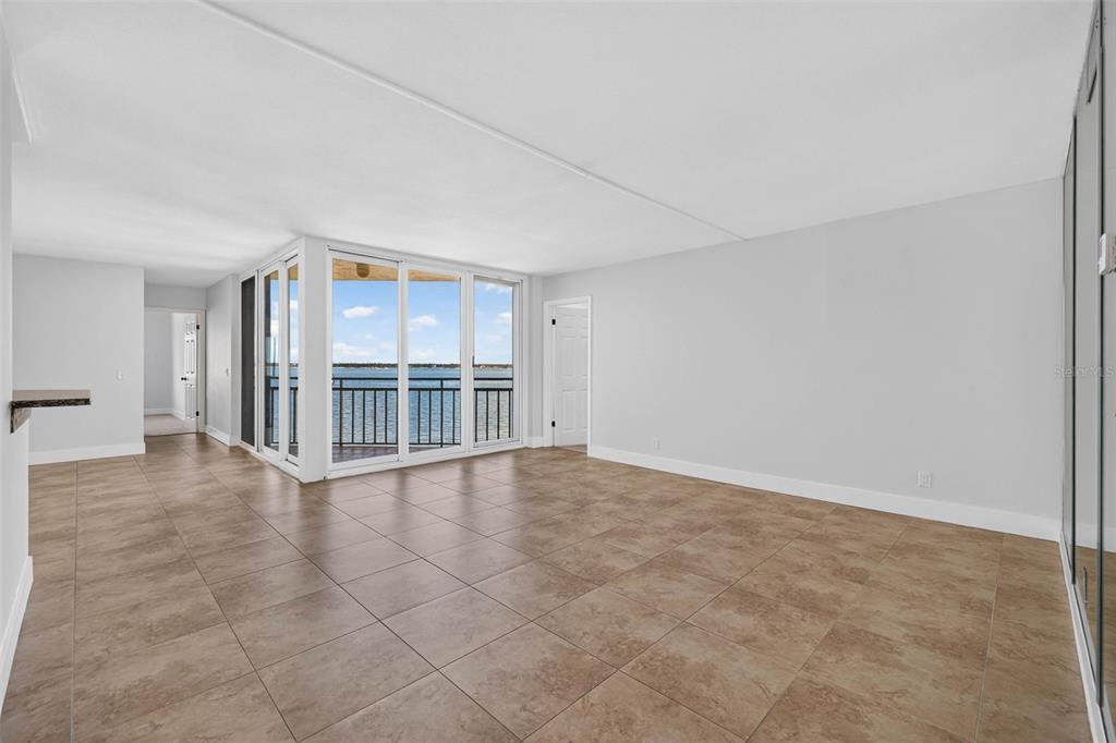 An open living area with large windows overlooking the water and light-colored tile flooring — 5541 PUERTA DEL SOL BOULEVARD S UNIT 412, ST PETERSBURG, FL