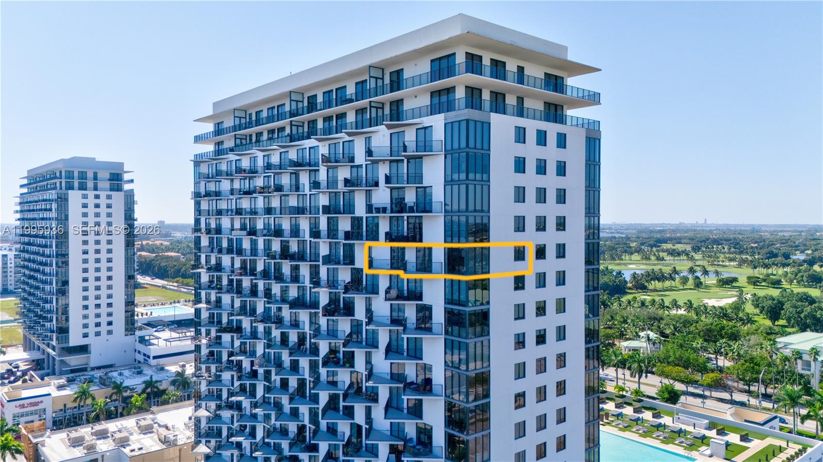 An aerial view of a modern high-rise building with a highlighted balcony section — 5300 NW 85th St # 1511, Doral FL 33166, DORAL, FL