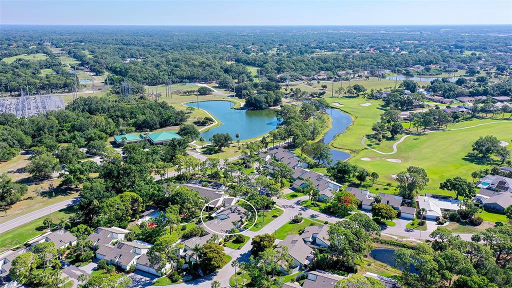 An aerial view shows a residential neighborhood with a golf course and a small lake — 4391 WOODMANS CHART UNIT 155, SARASOTA, FL