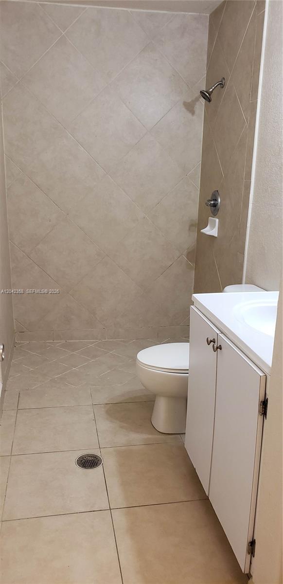 A small bathroom features a walk-in shower with beige tile and a white vanity — 138 NW 31st St # 138, Miami FL 33127, MIAMI, FL