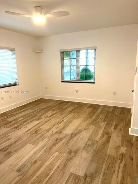 An empty room features light wood-look tile flooring, white walls, and a ceiling fan — 1553 Jefferson Ave # 1, Miami Beach FL 33139, MIAMI BEACH, FL