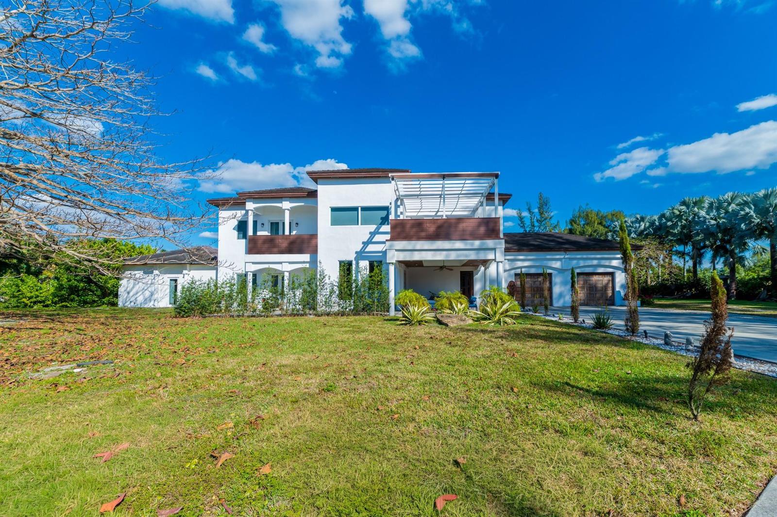 A two-story white modern house features a balcony, a pergola, and an attached garage — 4501 SW 143rd Avenue, Miramar FL 33027, MIRAMAR, FL