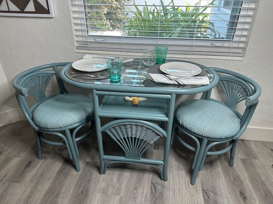 A blue wicker dining set with a glass top sits in front of a window — 1912 MORRILL UNIT 1920, SARASOTA, FL
