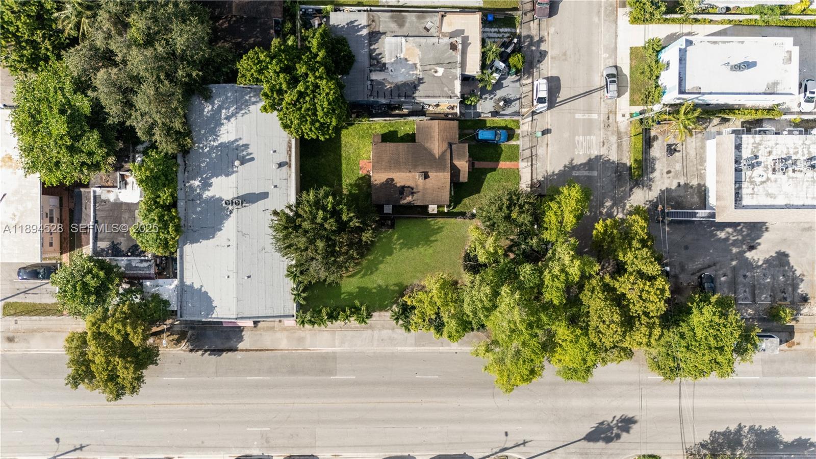 An aerial view shows a residential house with a brown roof surrounded by green trees — 1121 NW 29th St, Miami FL 33127, MIAMI, FL