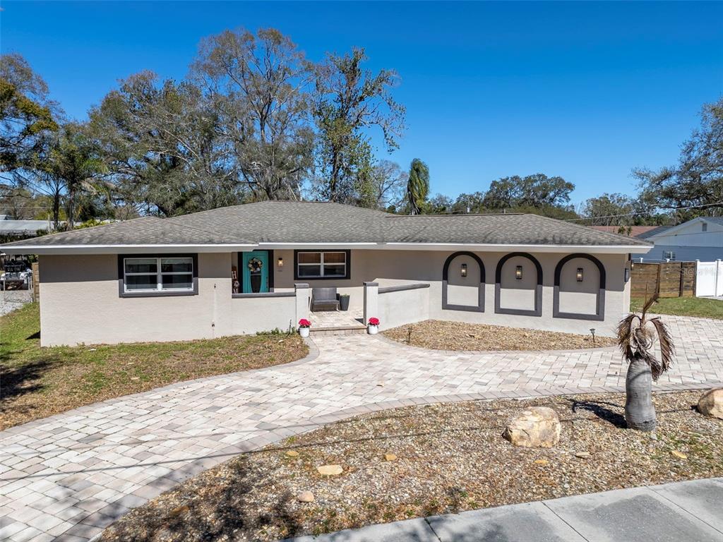 A single-story house features a paved driveway, a front porch, and three decorative arched wall accents — 2535 LAKE ELLEN DRIVE, TAMPA, FL