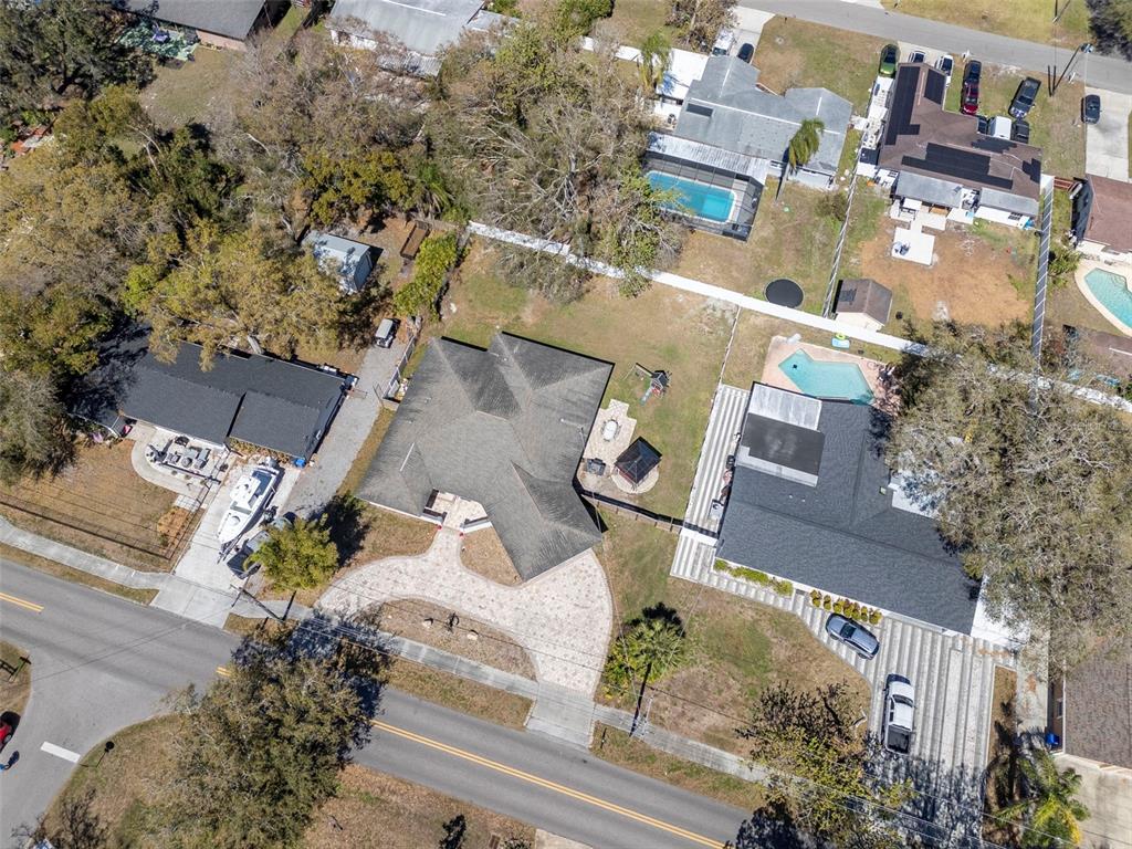An aerial view shows a residential property with a large driveway and backyard swimming pool — 2535 LAKE ELLEN DRIVE, TAMPA, FL