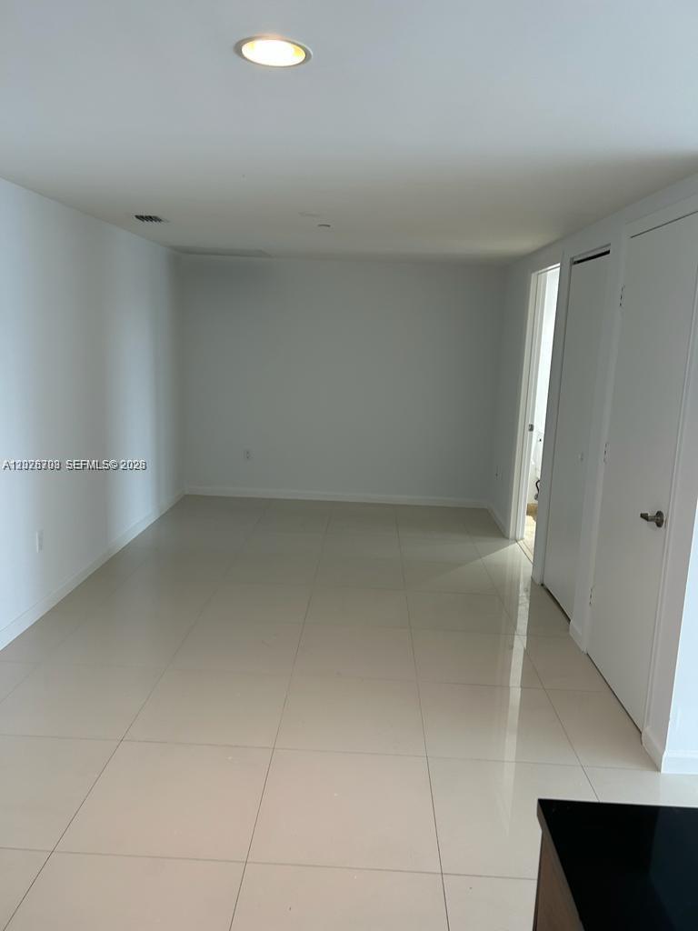 An empty room features white walls, light-colored tile flooring, and a single recessed ceiling light — 495 Brickell Ave # 3203, Miami FL 33131, MIAMI, FL