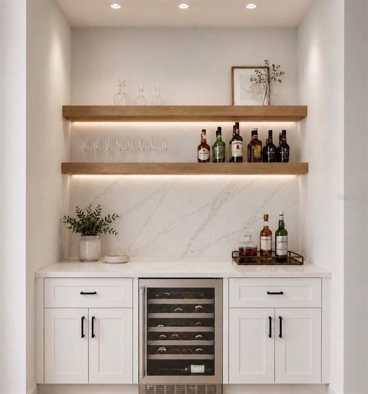 This home bar features white cabinetry, marble countertops, floating wood shelves, and a wine cooler — 4509 DALLAS BOULEVARD, ORLANDO, FL