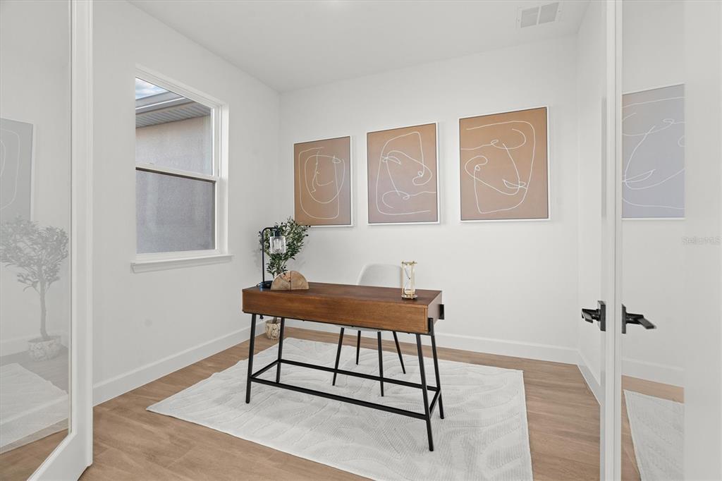 A home office features a wooden desk, a white rug, and three line-art wall prints — 4509 DALLAS BOULEVARD, ORLANDO, FL