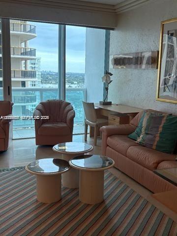 A living room features a sofa, an armchair, two round tables, and a desk — 10101 Collins Ave # 15D, Bal Harbour FL 33154, BAL HARBOUR, FL