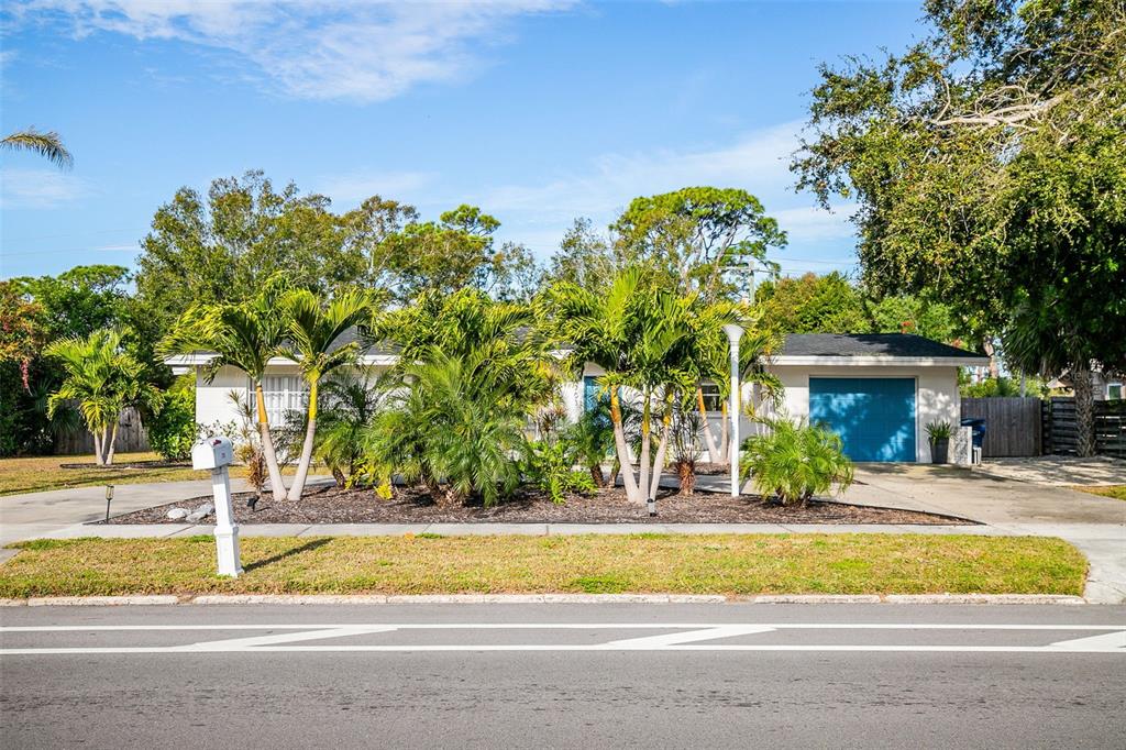 A single-story house with a blue garage door and palm trees in the front yard — 703 WHITFIELD AVENUE, SARASOTA, FL