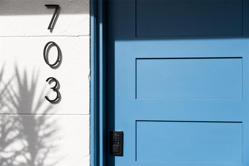 A blue door with a keypad lock sits next to the house number 703 — 703 WHITFIELD AVENUE, SARASOTA, FL