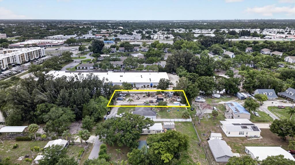 An aerial view shows a rectangular lot outlined in yellow amidst a residential neighborhood — 6353 143RD AVENUE, CLEARWATER, FL