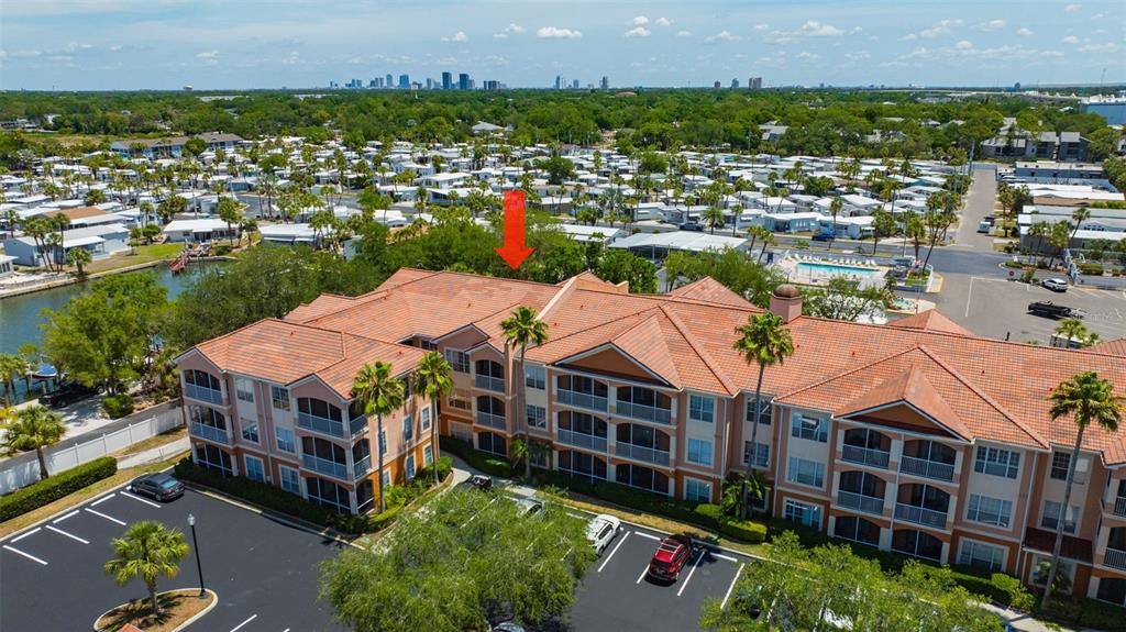 An aerial view shows a multi-story apartment building with a red tile roof and parking — 5000 CULBREATH KEY WAY UNIT 1-306, TAMPA, FL