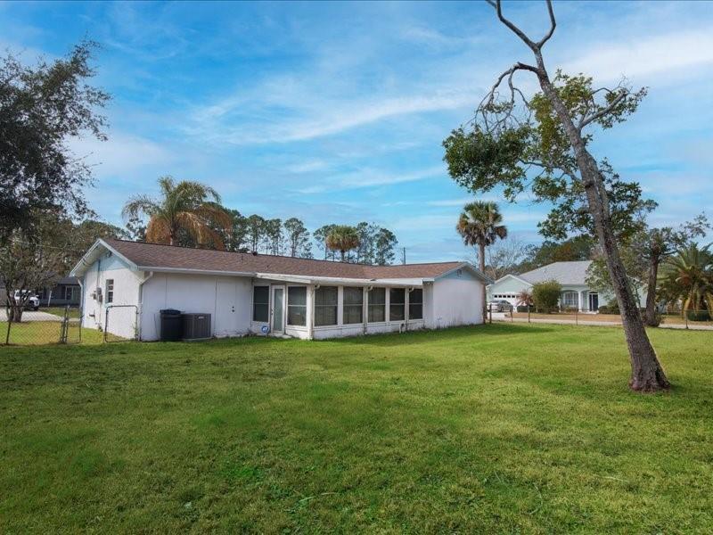 A single-story house with a screened-in porch sits on a large, grassy lot — 1 Westcliffe Lane, Palm Coast FL 32164, PALM COAST, FL