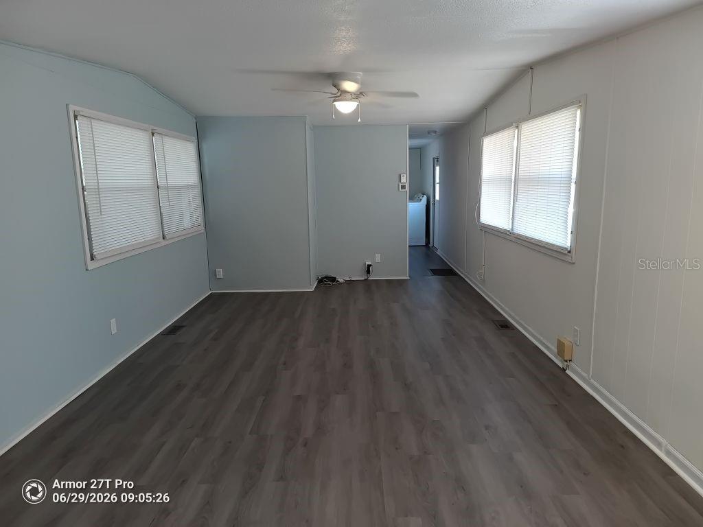 An empty room features light blue walls, grey wood-look flooring, and a ceiling fan — 5031 4TH STREET E, BRADENTON, FL