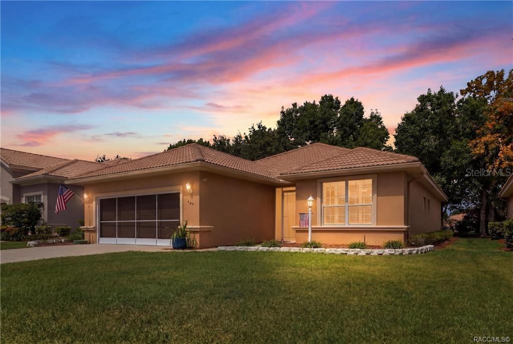 A single-story tan stucco house with a tiled roof and a two-car garage at dusk — 984 W SILVER MEADOW LOOP, HERNANDO, FL